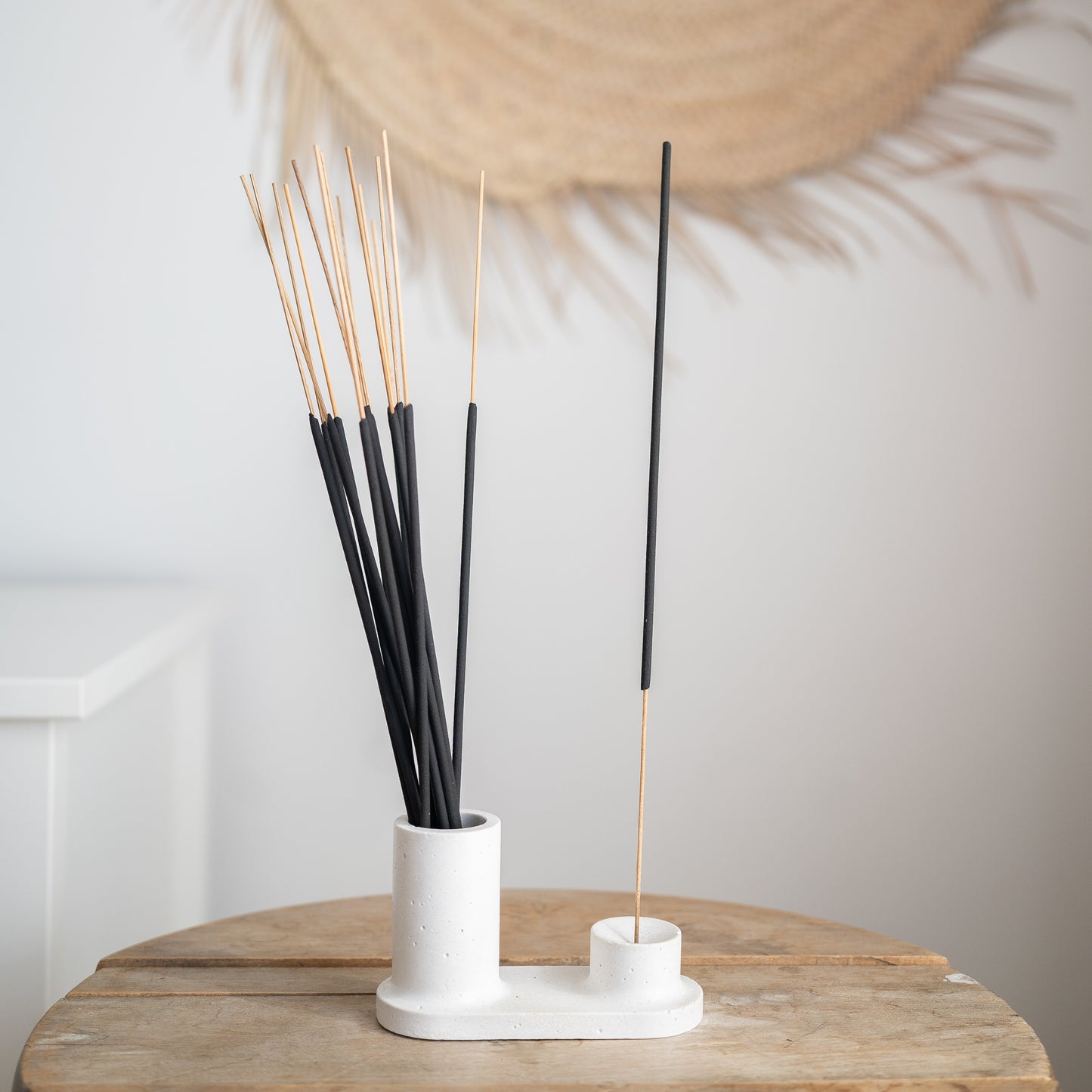 Circular incense holder hand-made with white cement. Incense are shown in the holder, with an area to burn an incense stick, and an area to store extra incense. Made by Paige Soy Candles