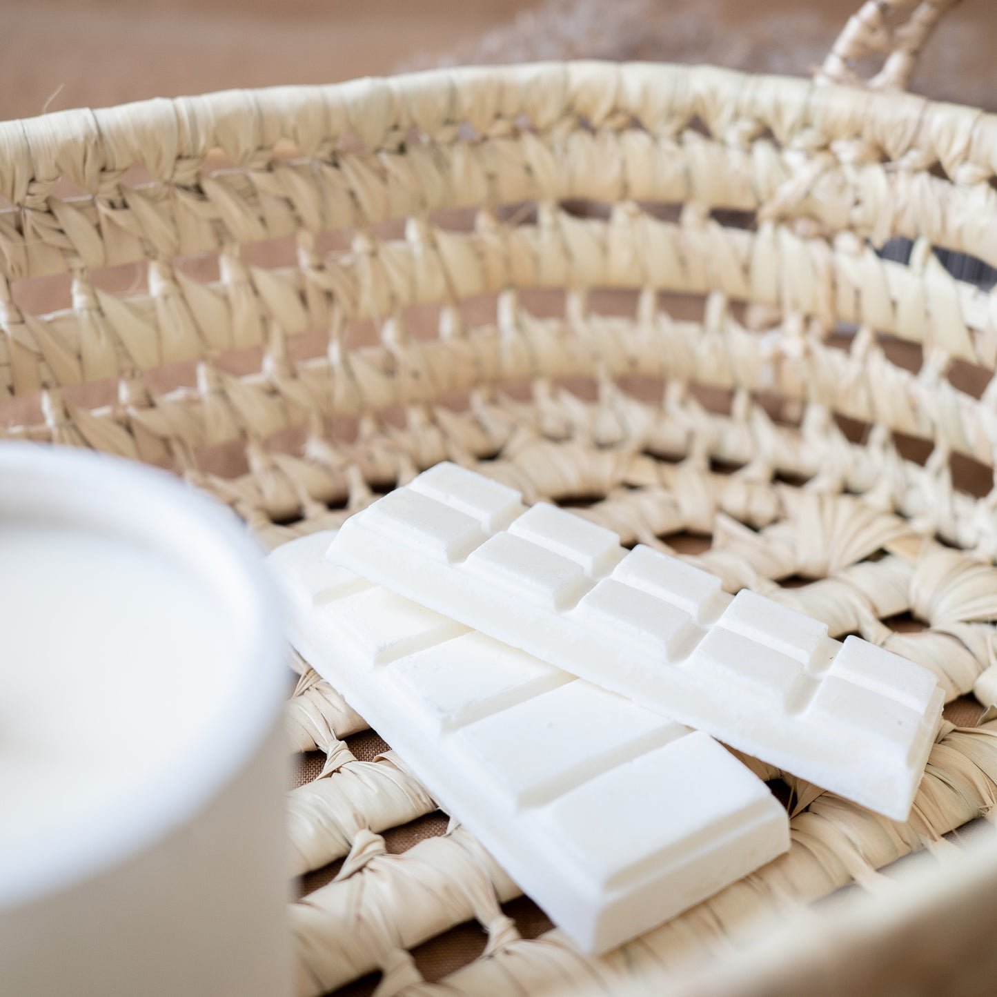 Two break-away wax melts laying in a basket. Made by Paige Soy Candles
